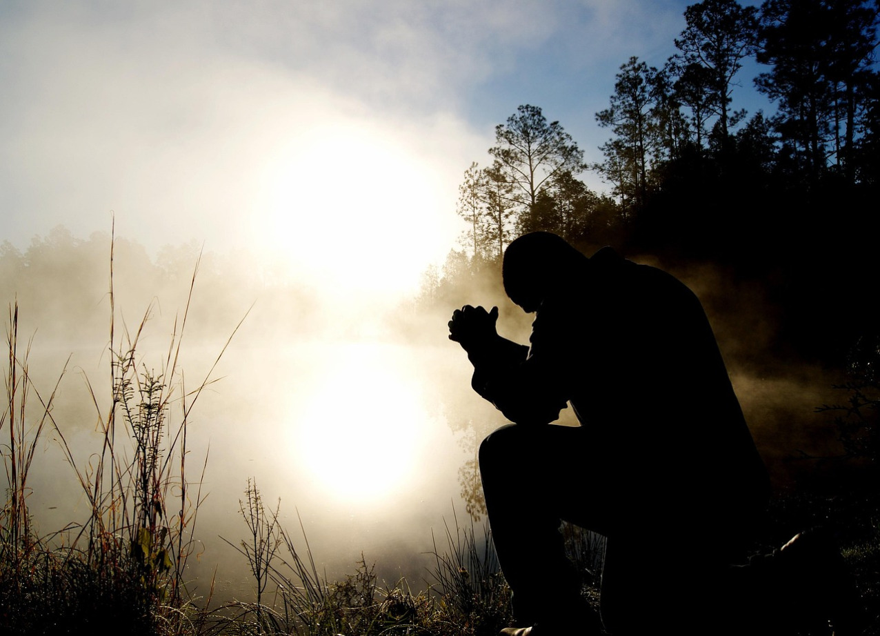 men praying circle outdoors